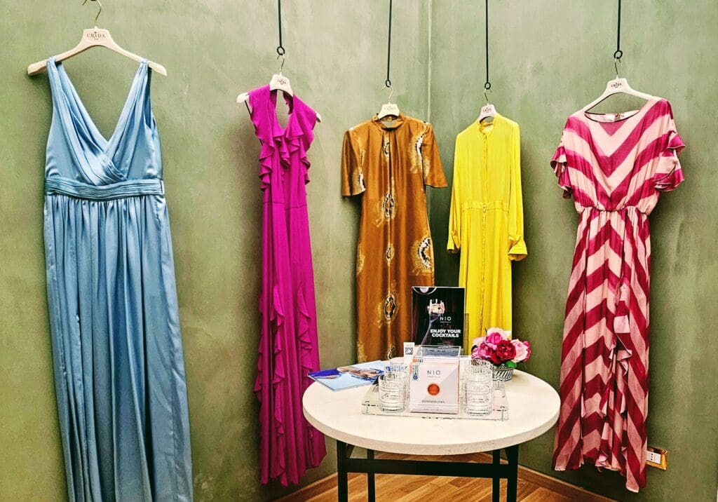 5 handsewn designer gowns hanging on display in Italy