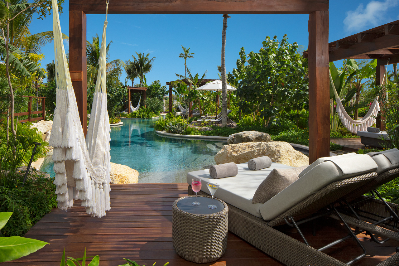 Luxe lounger on deck overlooking tropical pool