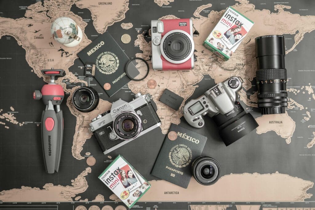Black and tan world map background with several cameras and passport