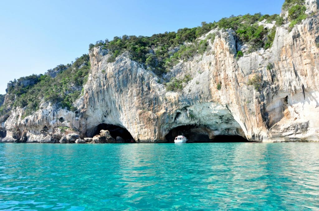 View from the sea looking towards the Italian cliffs with large caves below to explore by boat