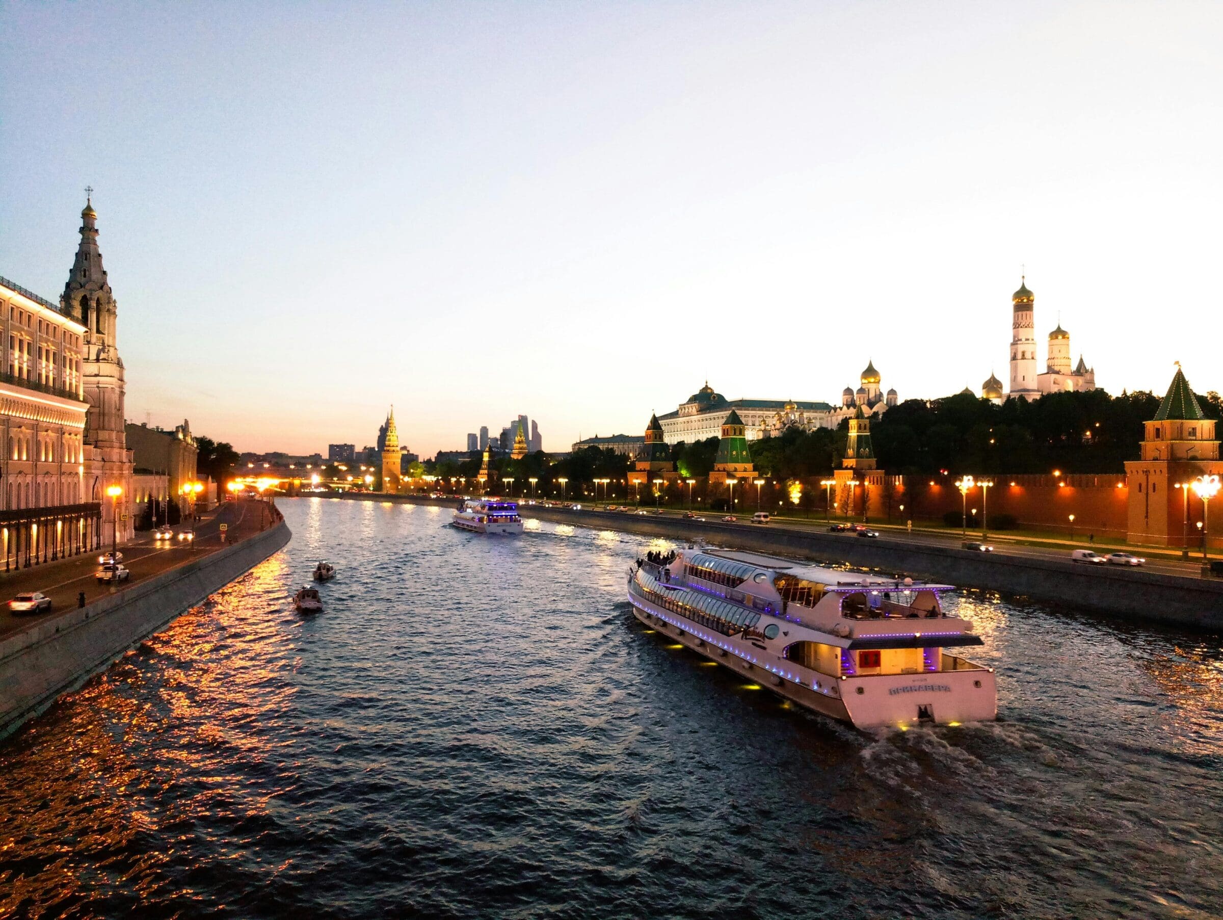 Boat cruising down a European river at sunset
