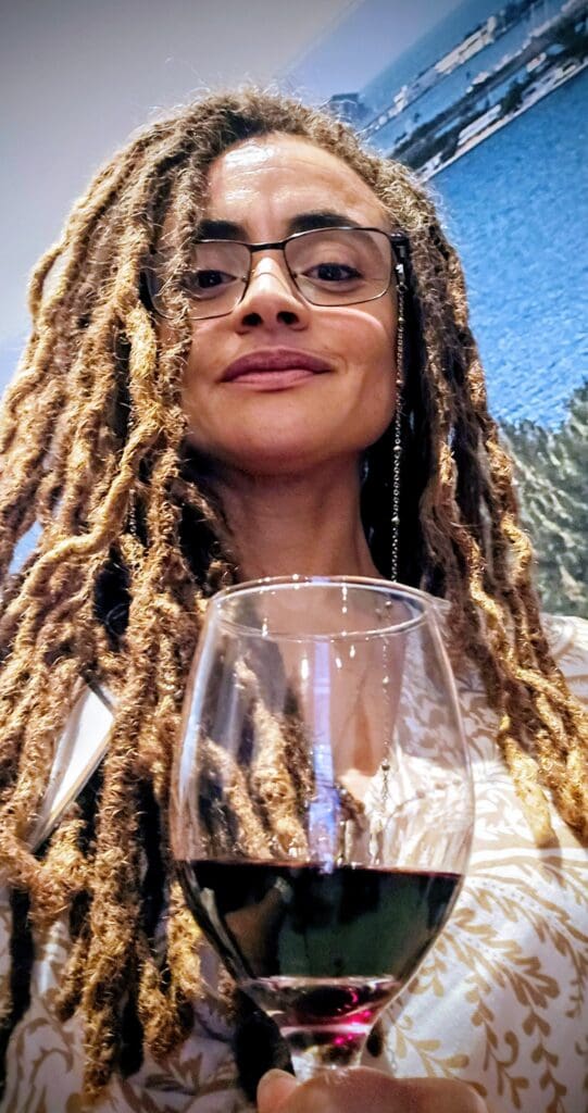 Woman with locs holding glass of wine 