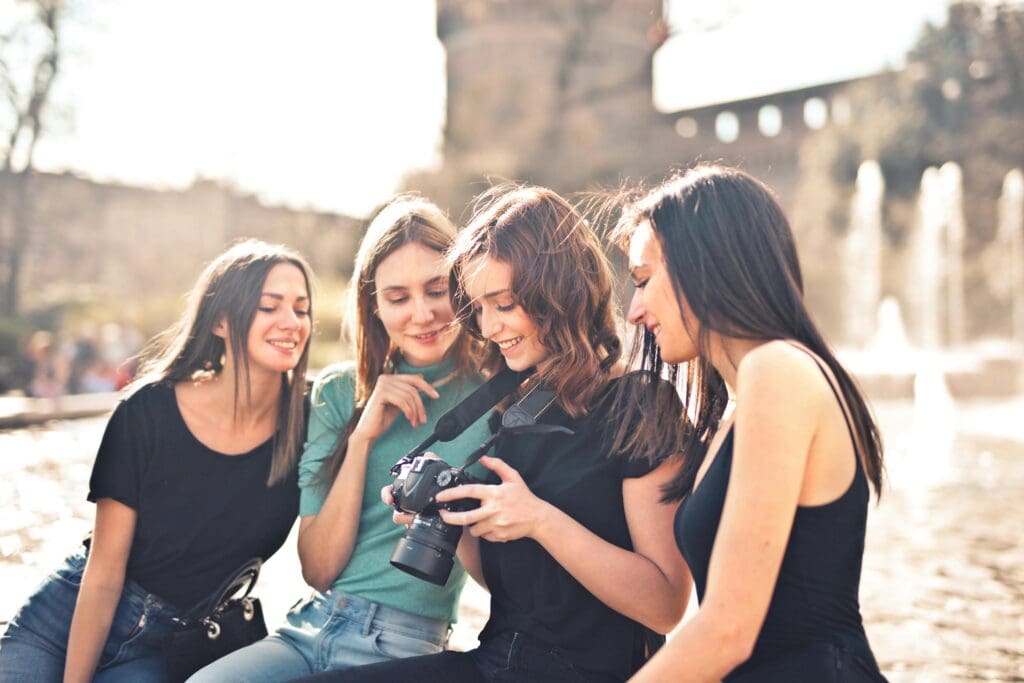 4 women sitting together looking into a camera