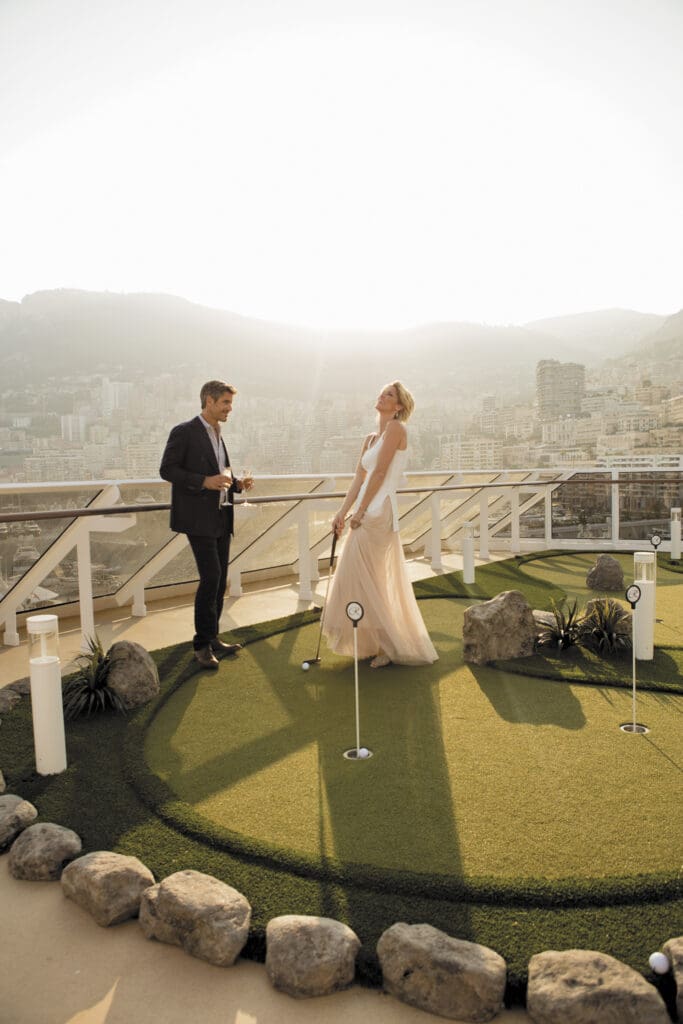fancy couple in formal wear with champagne glasses on the putting green on board a Reagent Seven Seas Ship in Port.