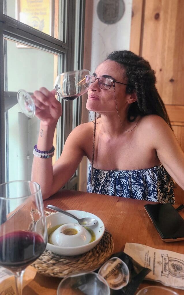women with closed eyes savoring glass of wine