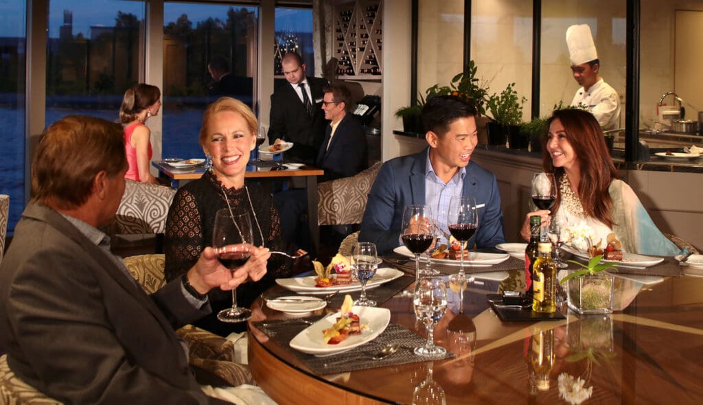 two couples enjoy and meal with wine at the chef's table on the AmaPrima