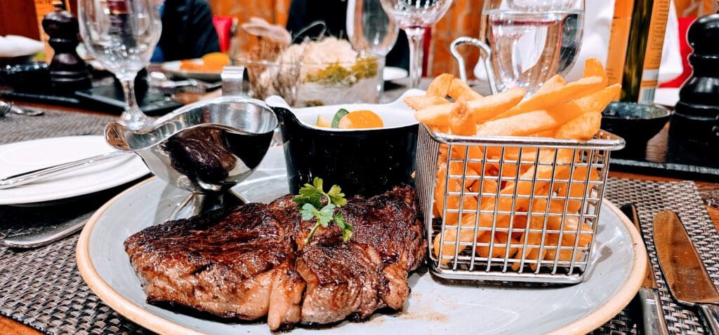 perfectly seared ribeye steal with basket of fries on the AmaBella