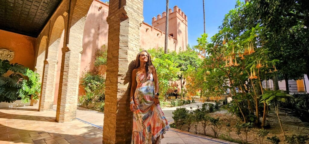 Woman posed against stone pillar is beautiful garden