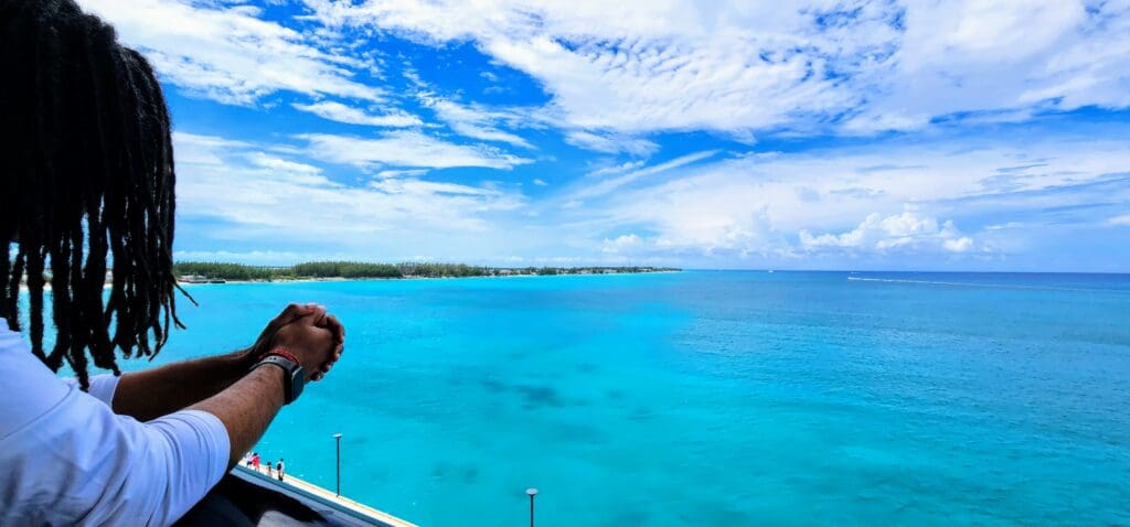 Man leaning over balcony w ocean view