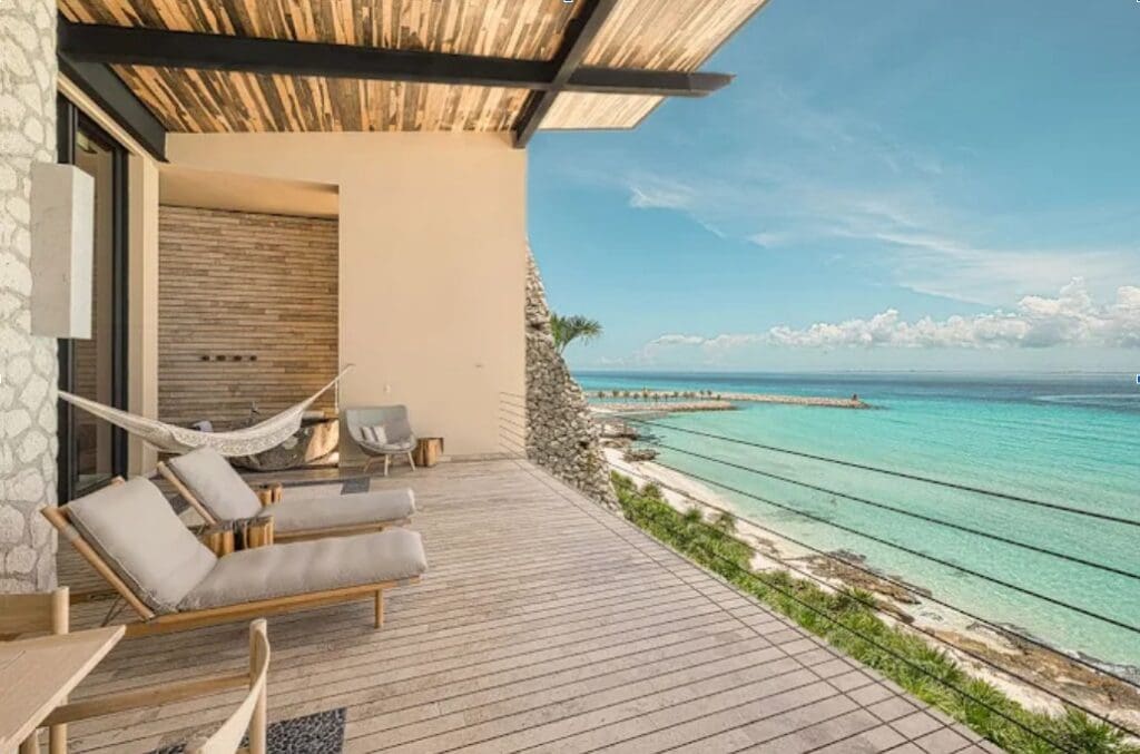 wooden decked balcony with loungers overlooking the Caribbean Sea at Casa de la Playa by Xcaret