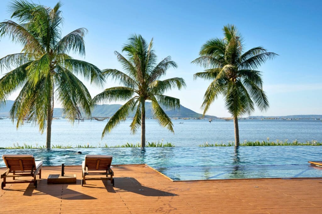 Relax by an exotic infinity pool with lush palm trees and a stunning ocean backdrop.
