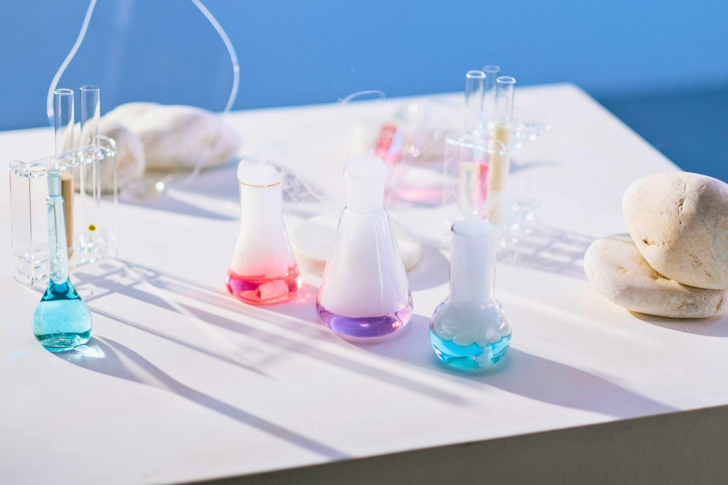 3 glass beakers with colorful liquids and smoke