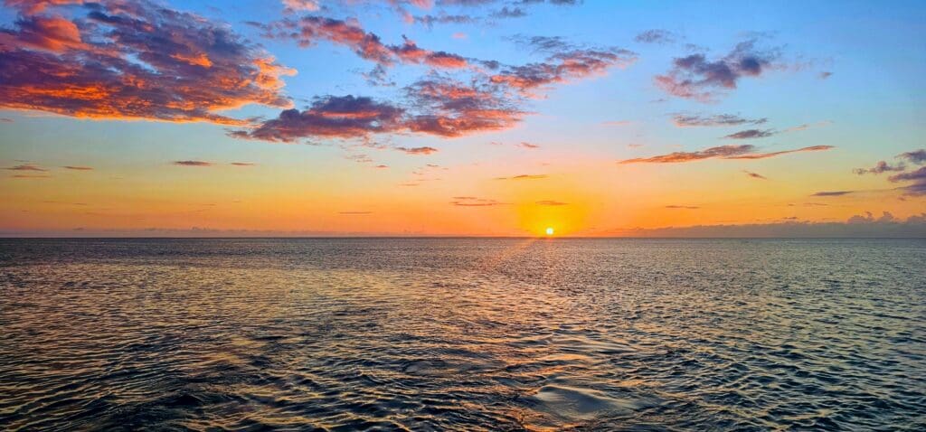 Rainbow skys as the sunsets on the ocean horizon.