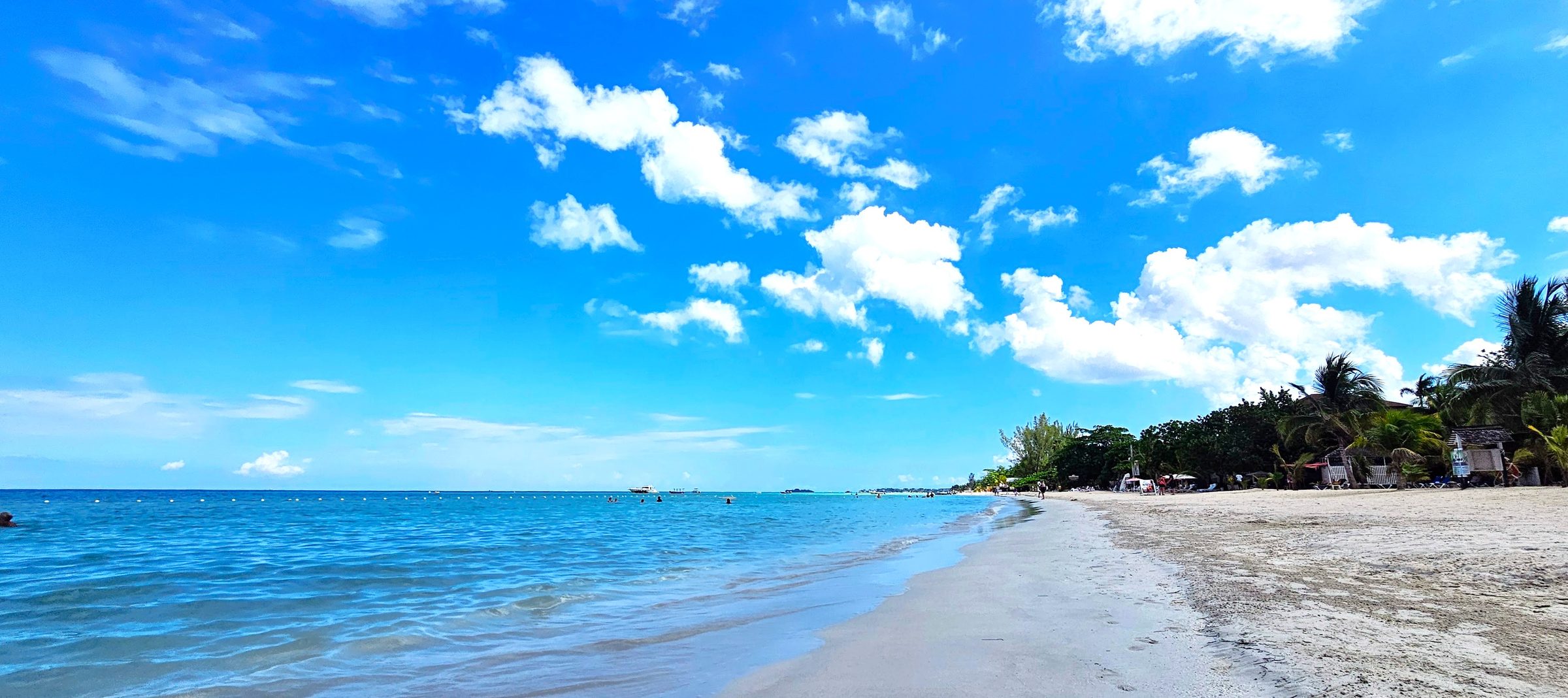 Bright blue sky and ocean with white sand at Negril's seven mile beach